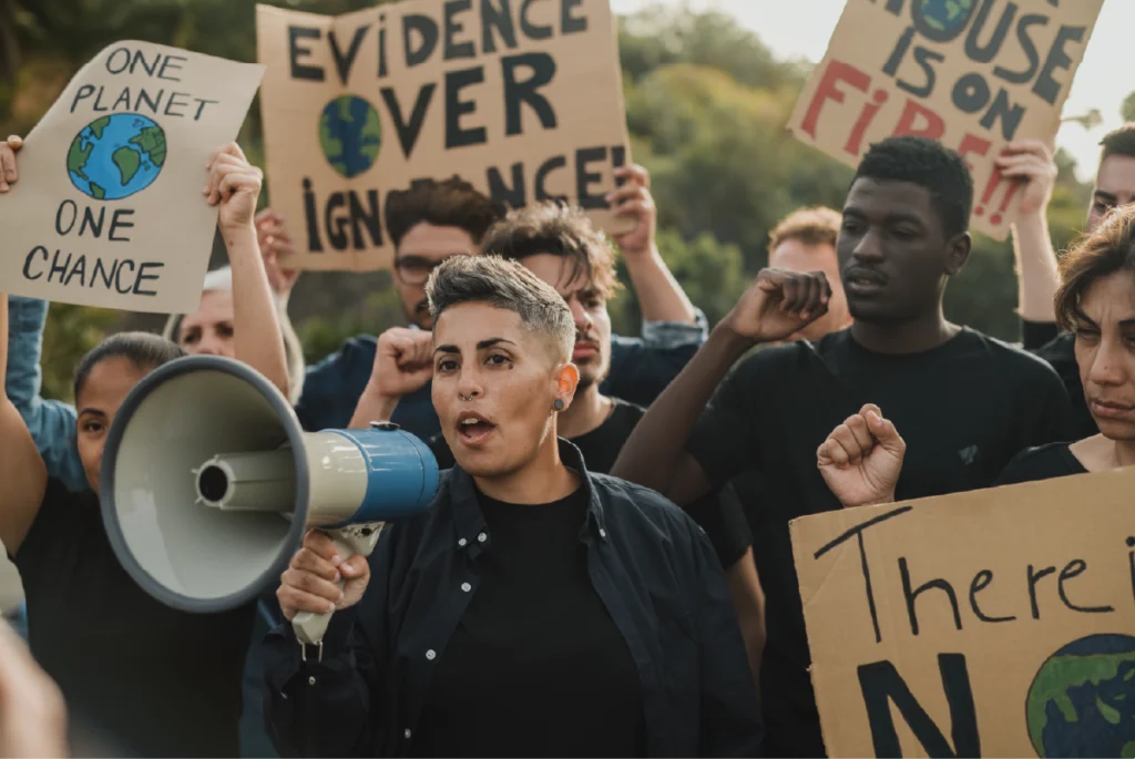 People dressed in black holding protest signs and a megaphone, illustrating black’s association with rebellion and resistance.